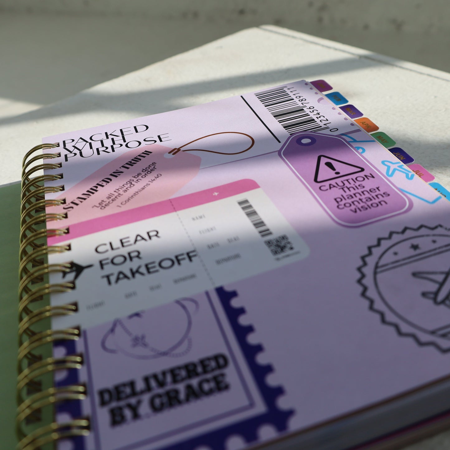 Spiral-bound notebook with colorful labels and stickers on a light surface