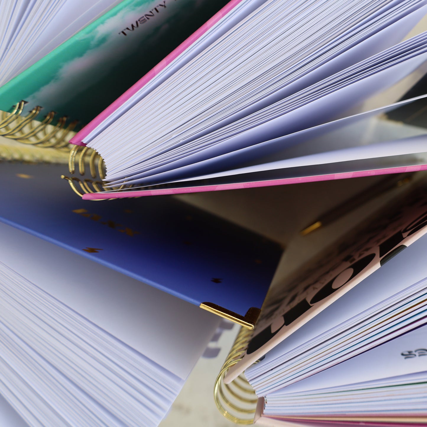 Stack of open notebooks with colorful spines on a light surface