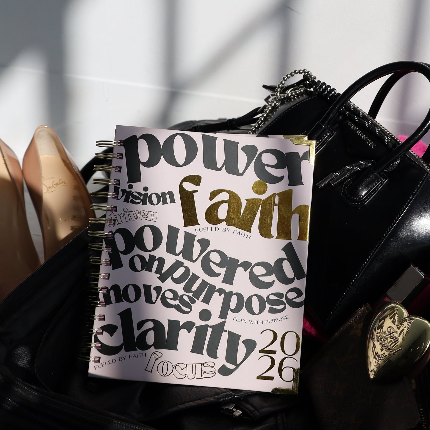Black handbag with motivational text on a white surface