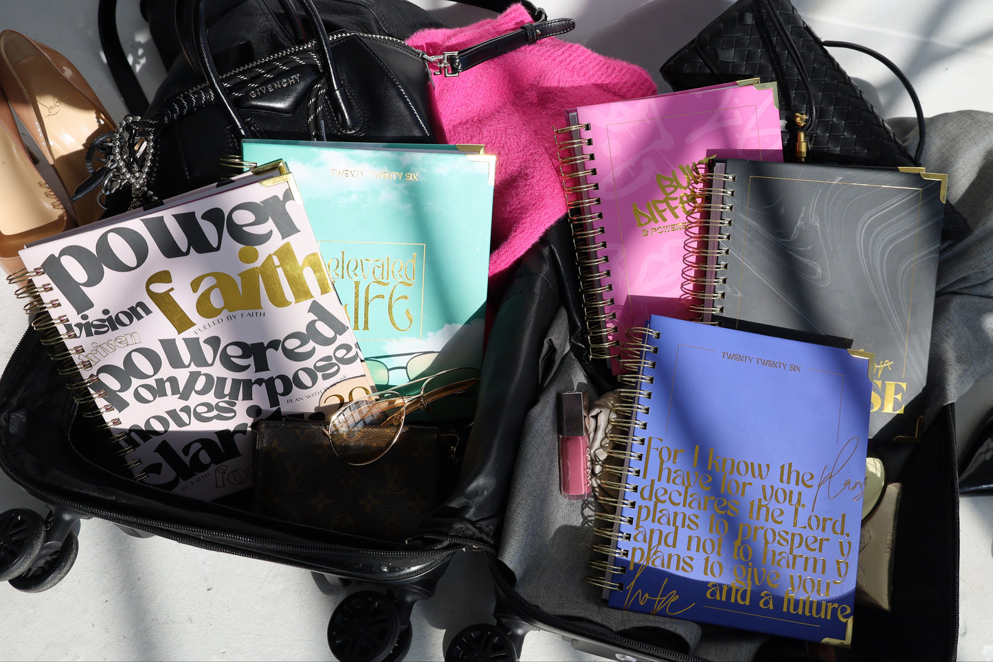 Collection of notebooks and a motivational poster on a white surface
